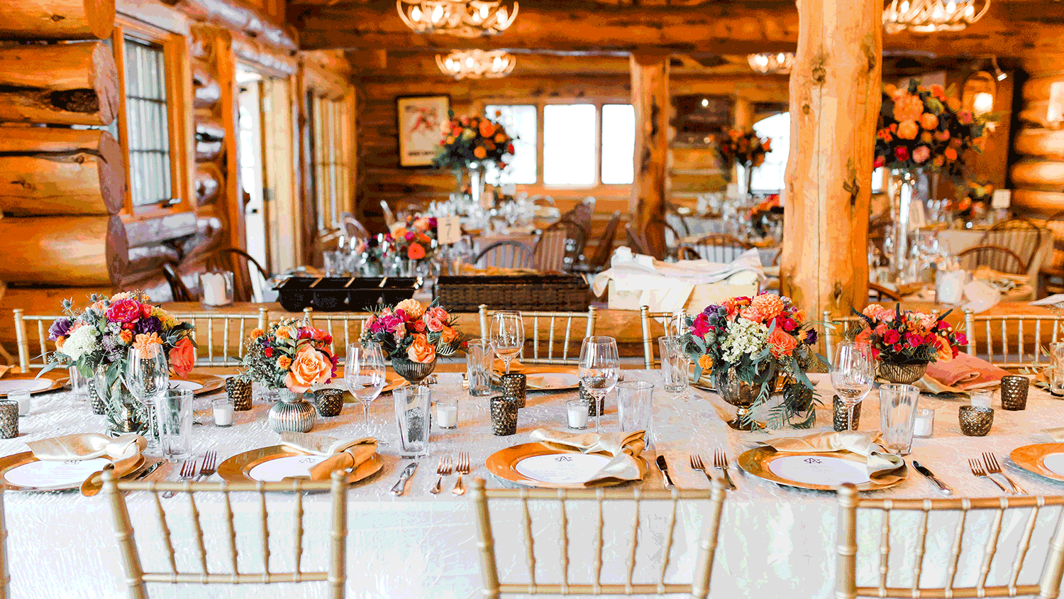 Pine Creek Cookhouse dressed for an elegant private event - gold chiavari chairs and floral centerpieces.